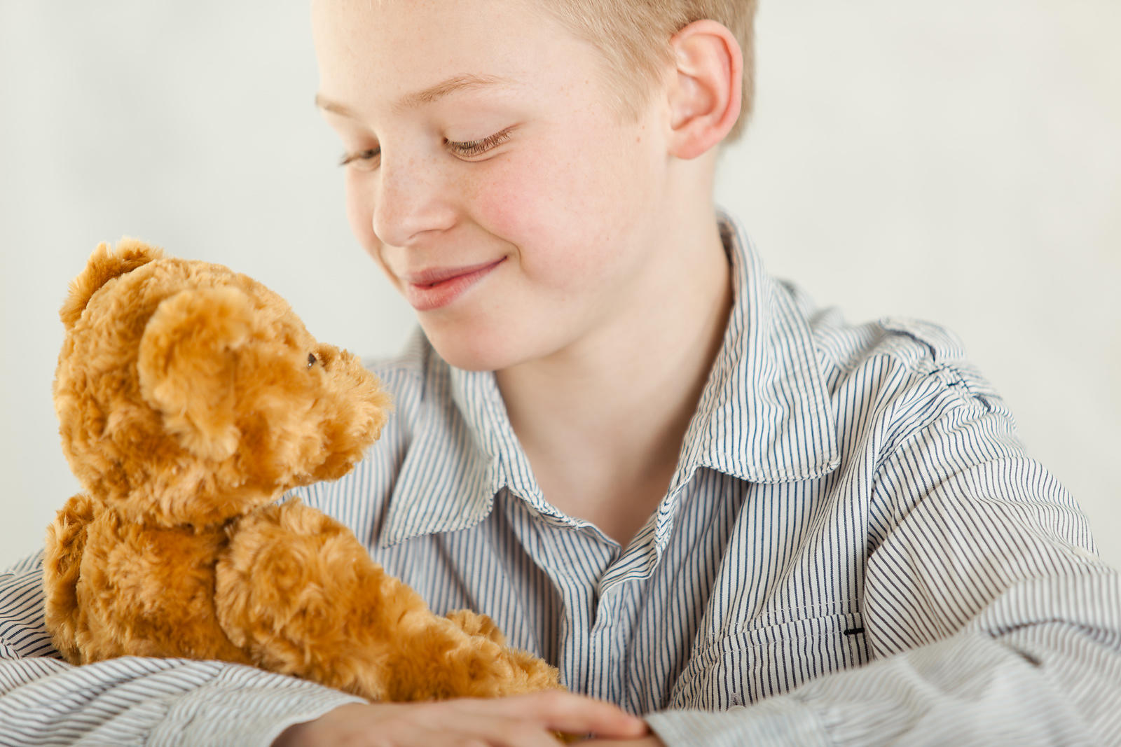 Young boy cuddling his teddy bear